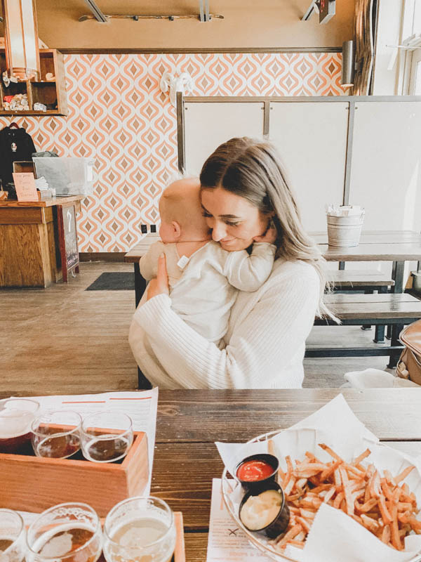 Girl holding baby at a brewery seven monk brewing