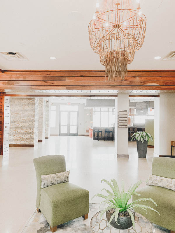 Lobby of Hotel Indigo in Traverse City, Michigan. Green chairs, plants and a bar.