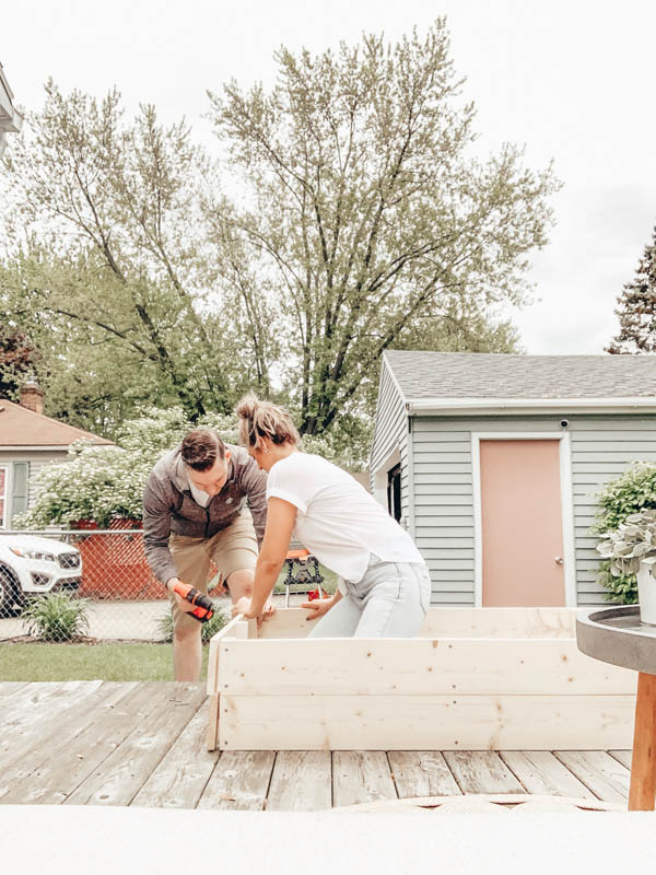 Man and woman putting together a raised garden bed
