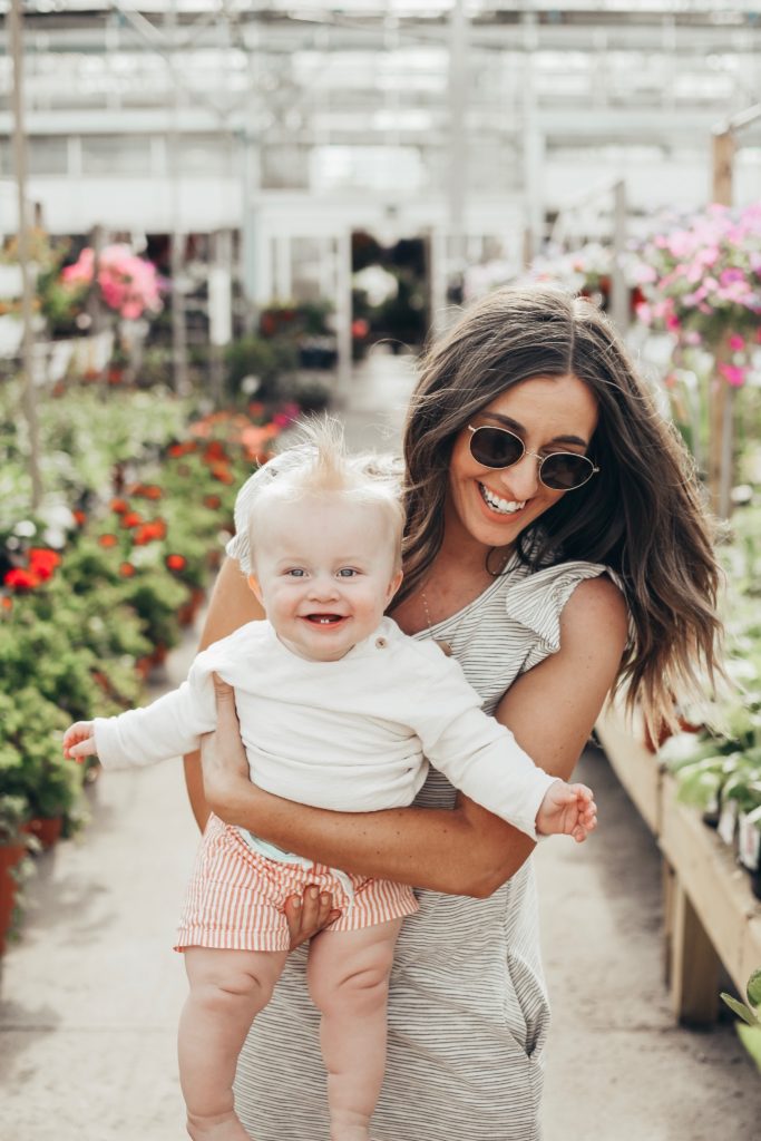 Girl in greenhouse with a baby