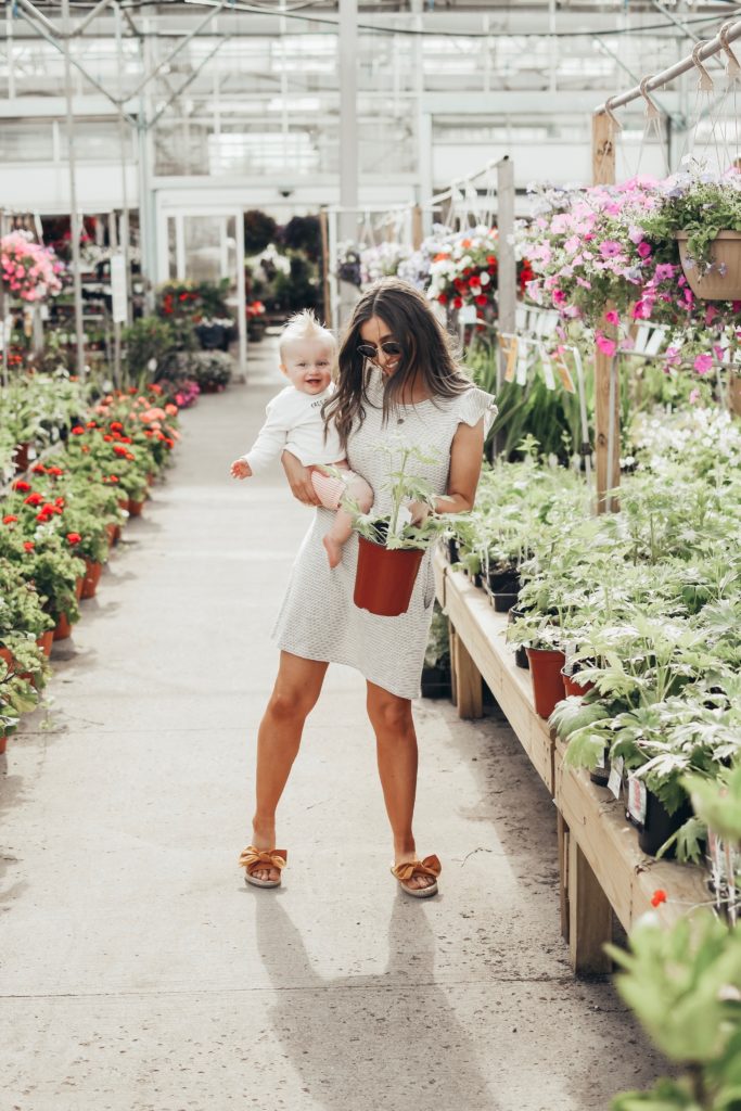 Girl in greenhouse with a baby