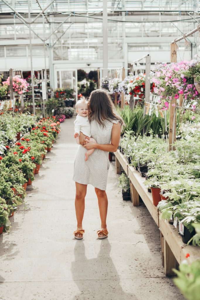 Girl in greenhouse with a baby