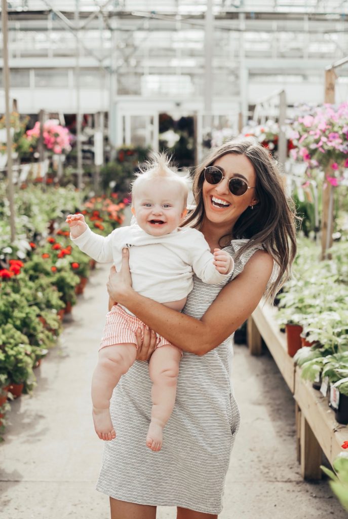 Girl in greenhouse with a baby