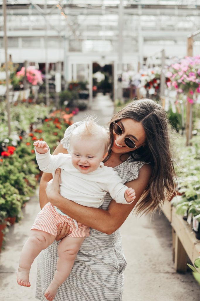 Girl in greenhouse with a baby