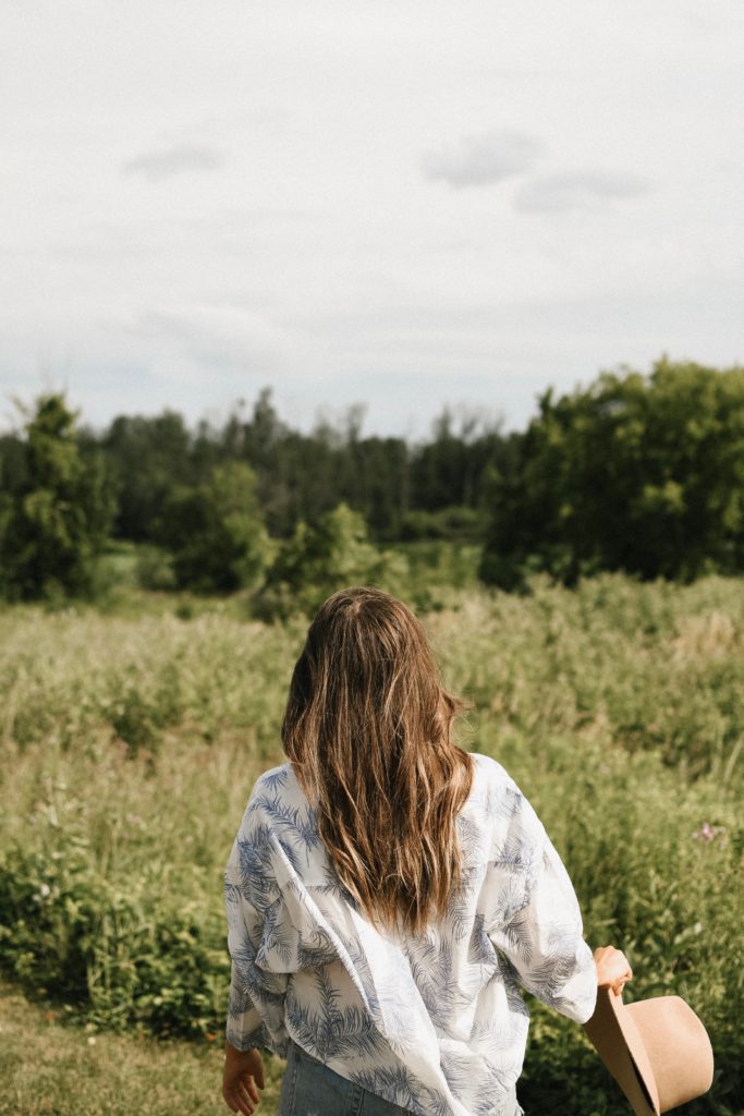 Girl in field with a hat