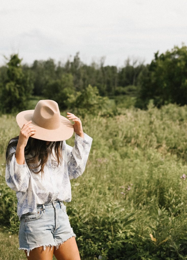 Girl in field with a hat