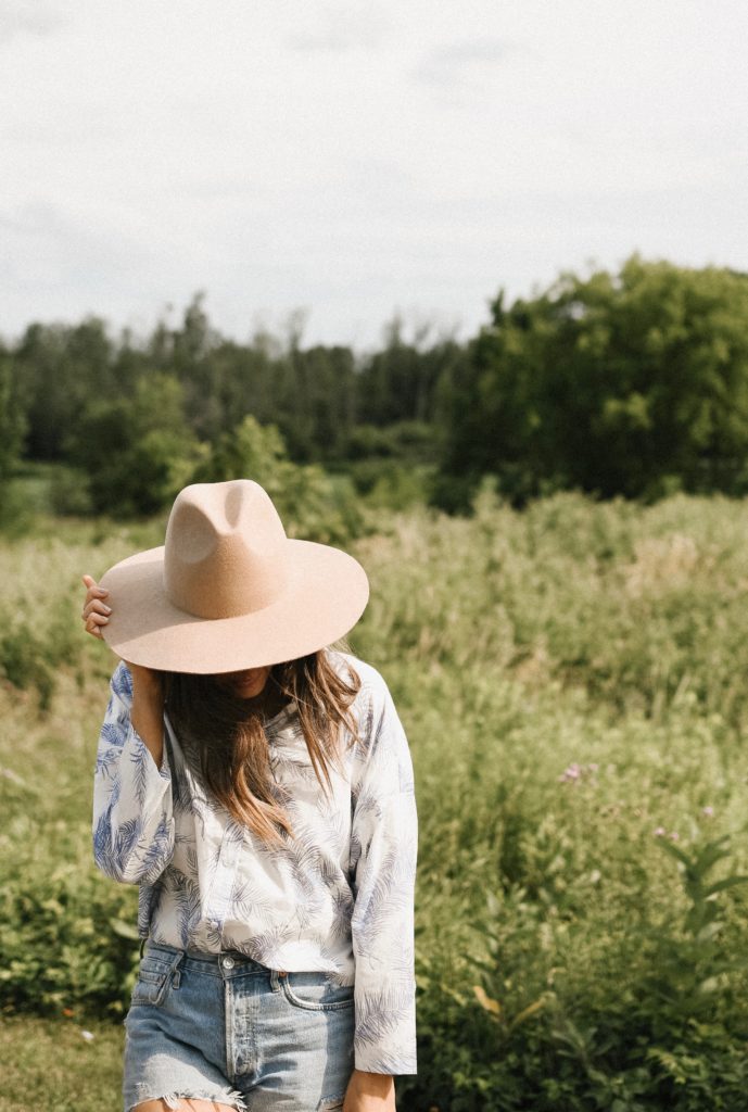 Girl in field with a hat