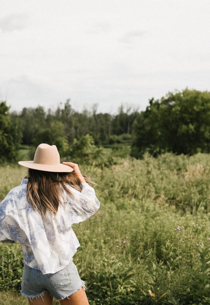 Girl in field with a hat