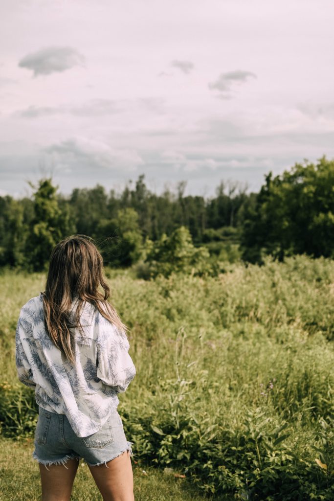 Girl in field with a hat